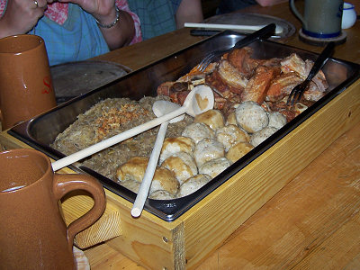 Krustenbraten und Schweinshaxen mit Bratensoße, dazu Brotknödel und Kraut